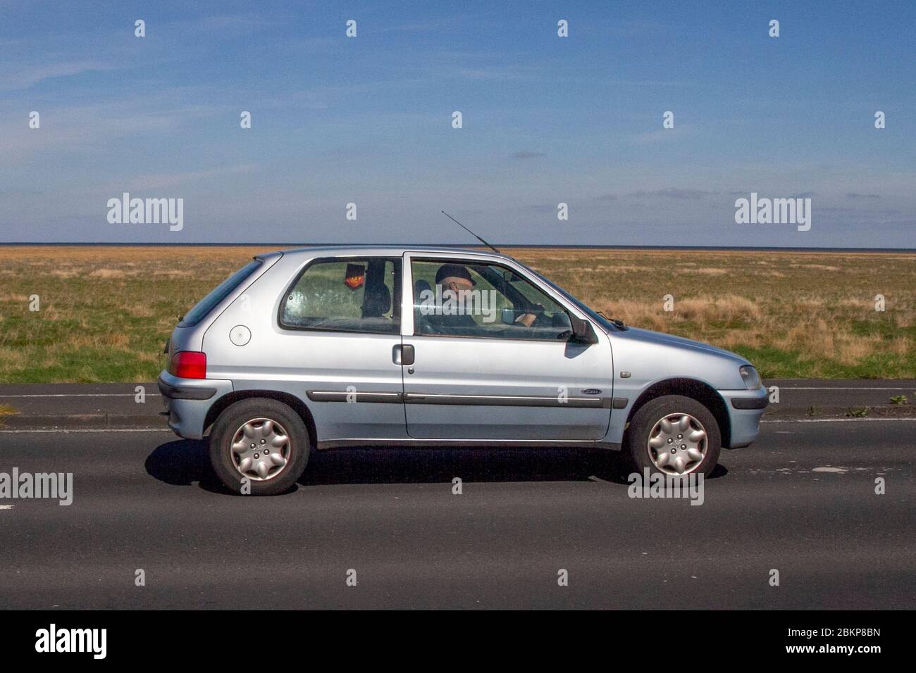 2002 silver Peugeot 106 Zest 2 Diesel; Vehicular traffic moving vehicles, driving vehicle on UK roads, motors, motoring on the coast road, Southport Merseyside UK Stock Photo