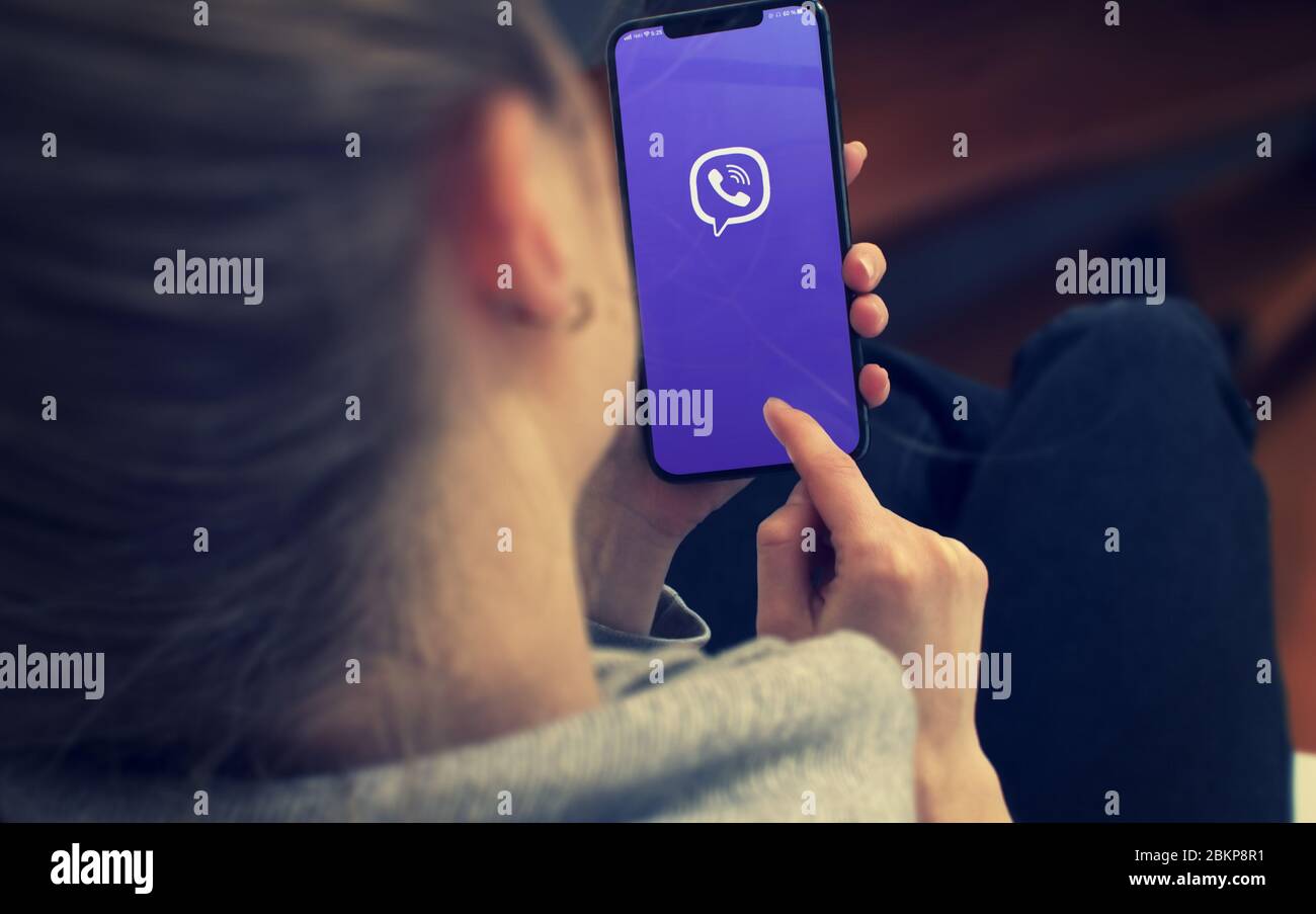 KYIV, UKRAINE-JANUARY, 2020: Viber on Smart Phone Screen. Young Girl Pointing or Texting in Viber on Mobile Phone During a Pandemic Self-Isolation and Coronavirus Prevention. Stock Photo