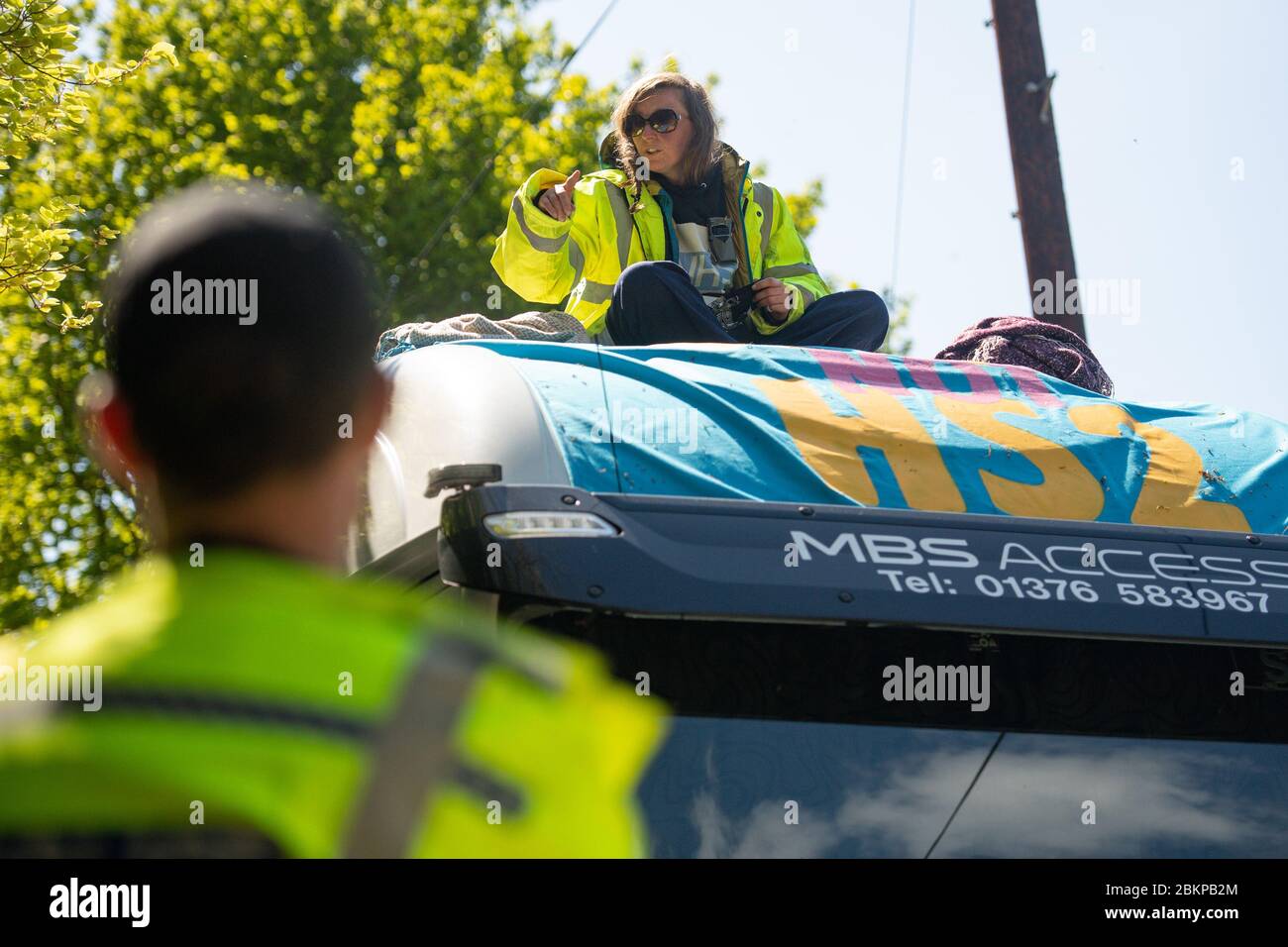 Police negotiate with an anti-HS2 campaigner who has positioned themselves on an articulated lorry, believed to be involved in the construction project, in Crackley Woods, near Kenilworth, Warwickshire. A group of protesters have set up a makeshift camp in the ancient woodland, which they claim is under threat from the construction of HS2. Stock Photo