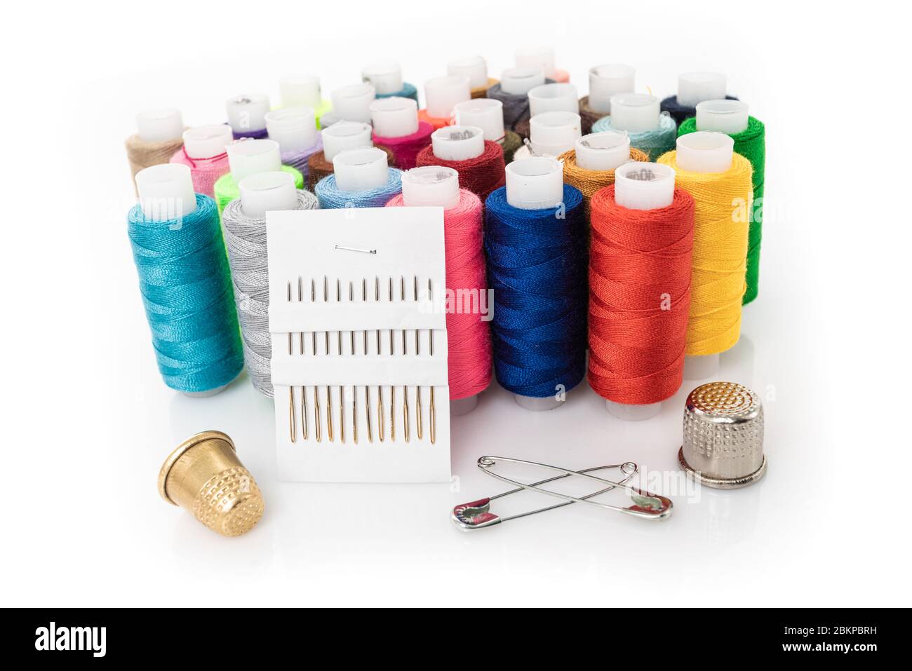 tailor needles and threads over white background Stock Photo