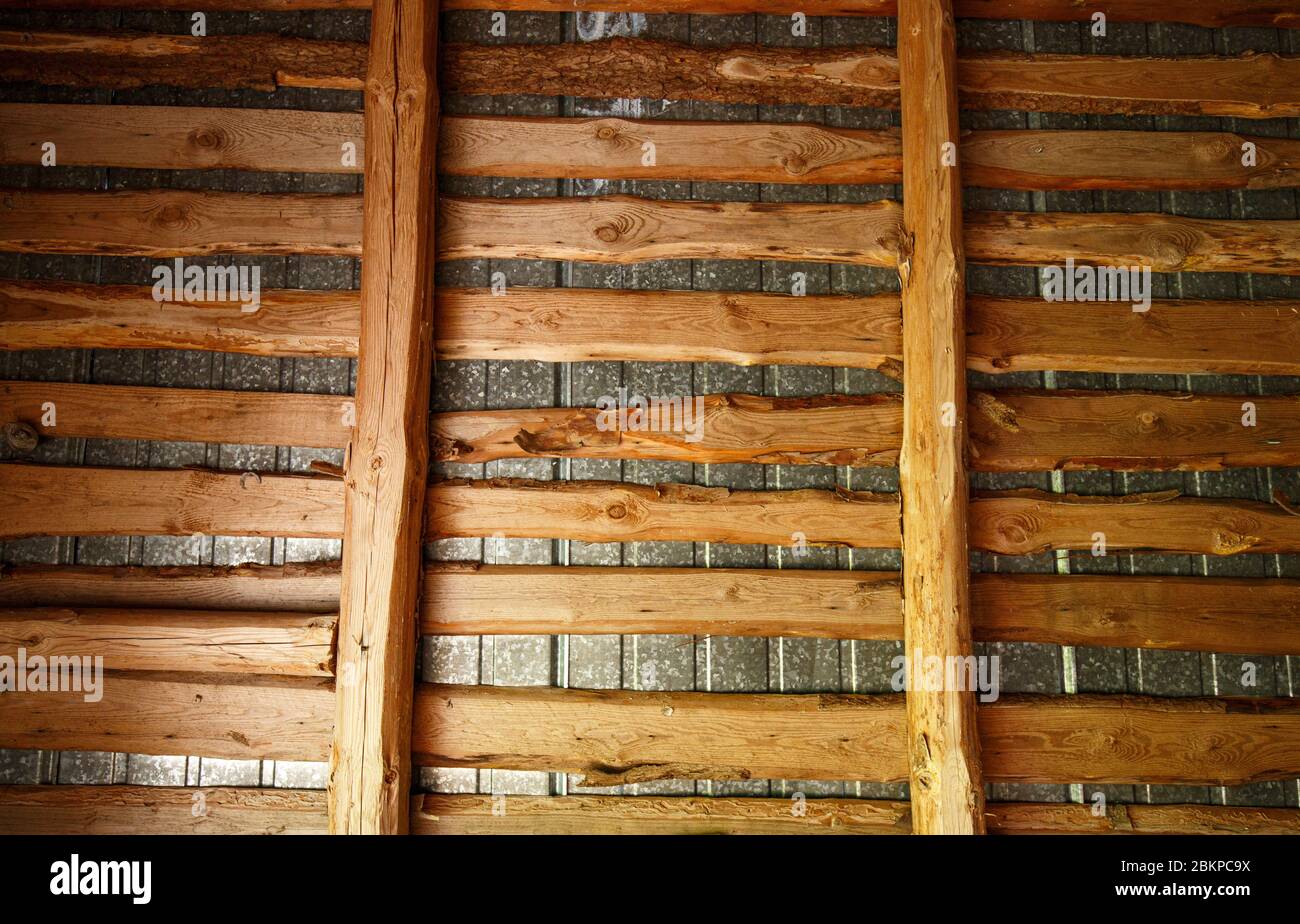Old barn tin roof understructure made of wooden planks and beams