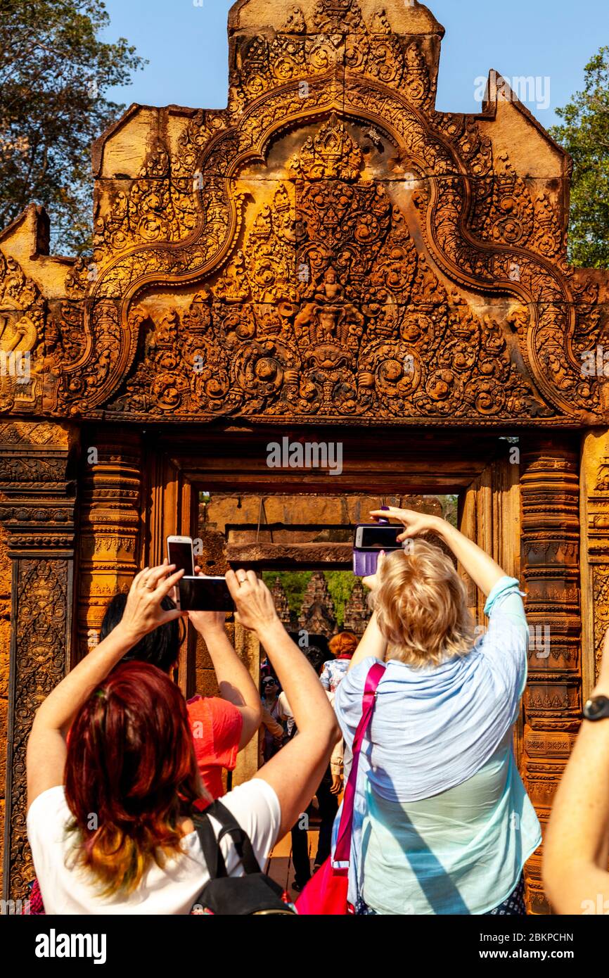Visitors taking Photographs At Banteay Srey Temple, Angkor Wat Temple Complex, Siem Reap, Cambodia. Stock Photo