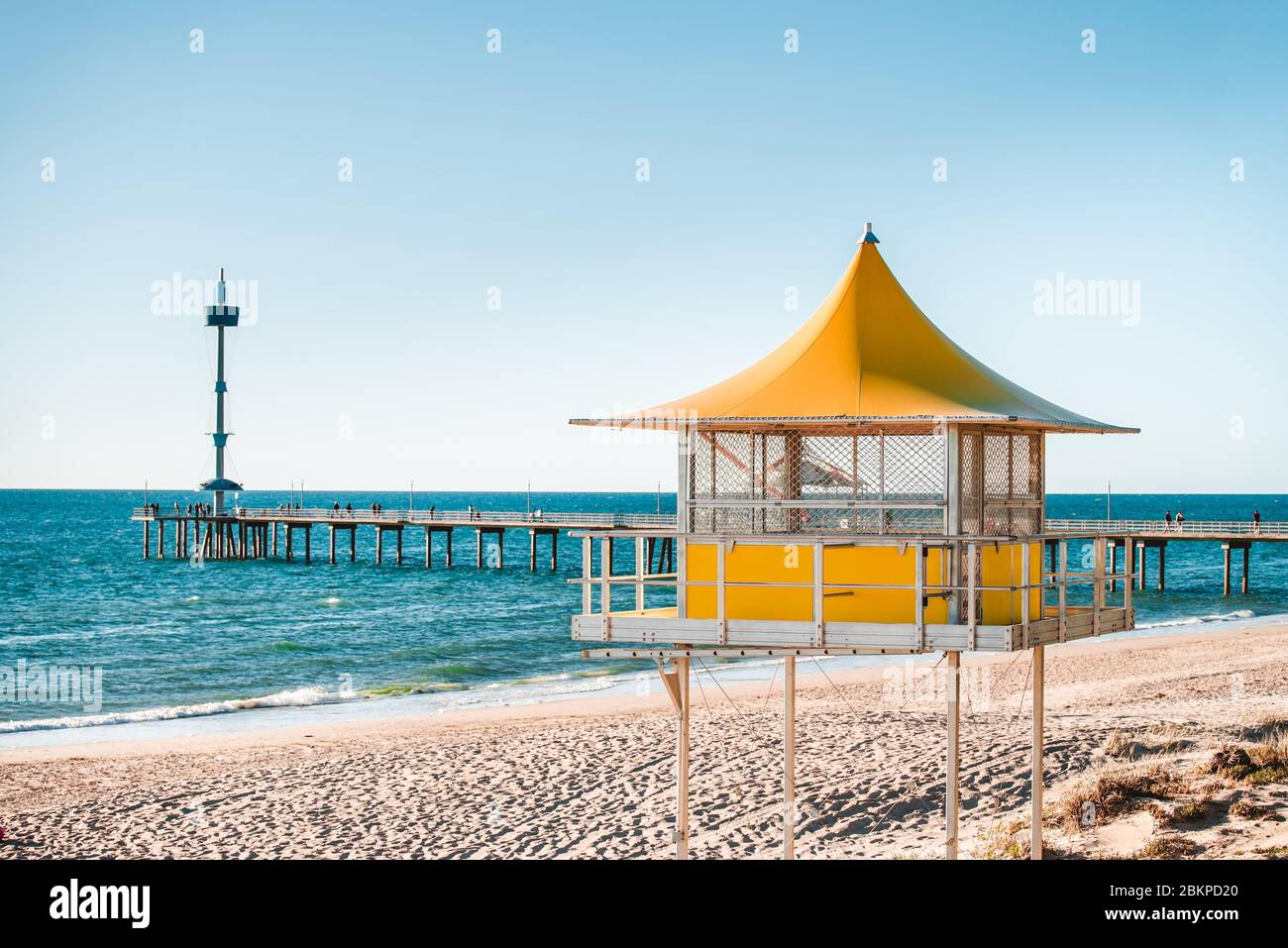 Brighton surf life saving tower with people walking along the jetty on the background, South Australia Stock Photo