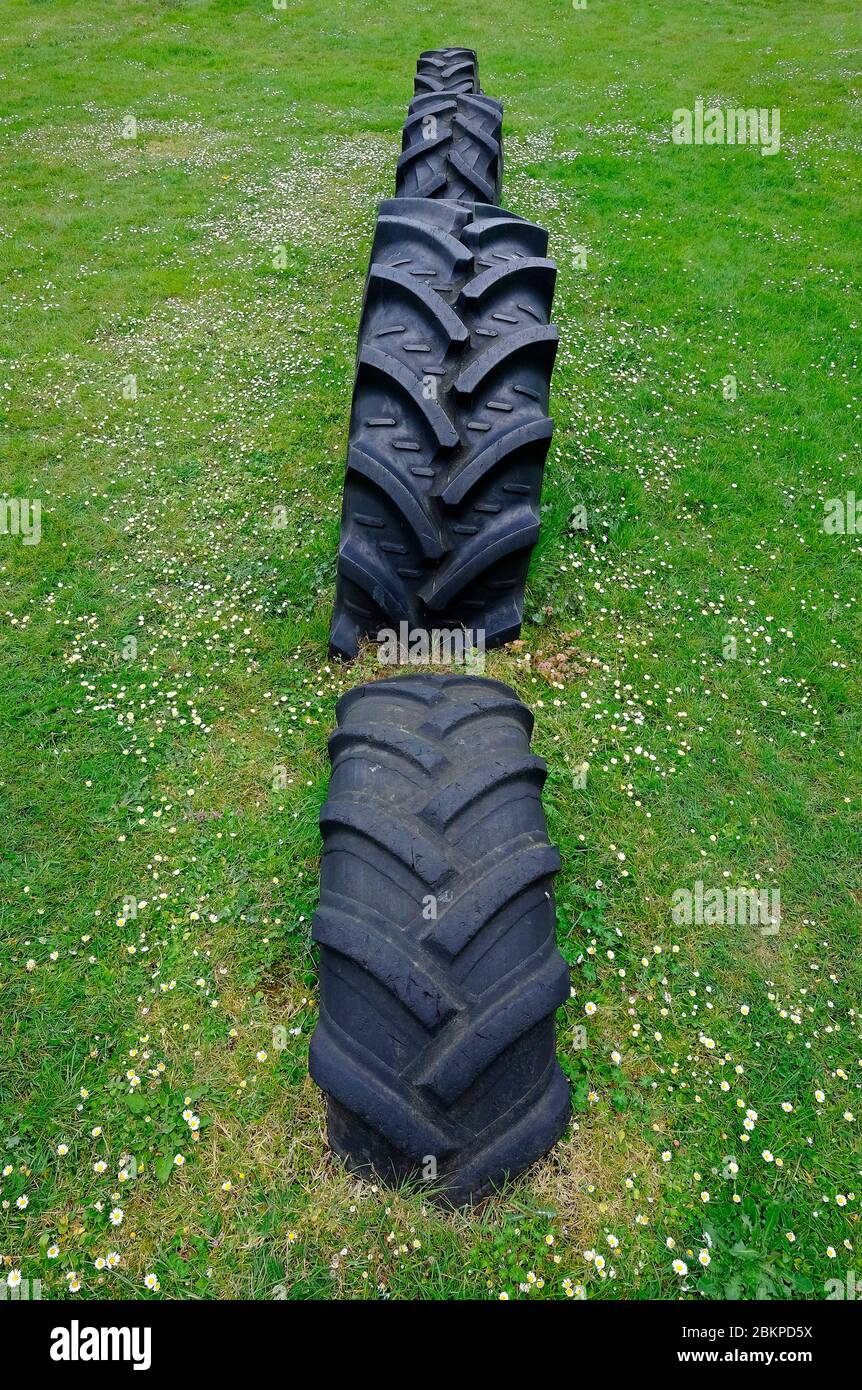 old tractor tyres buried in ground, norfolk, england Stock Photo