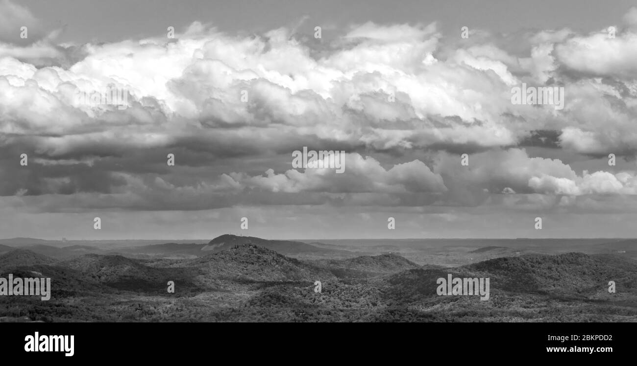 Layers of clouds casting shadows on hills in black and white Stock Photo