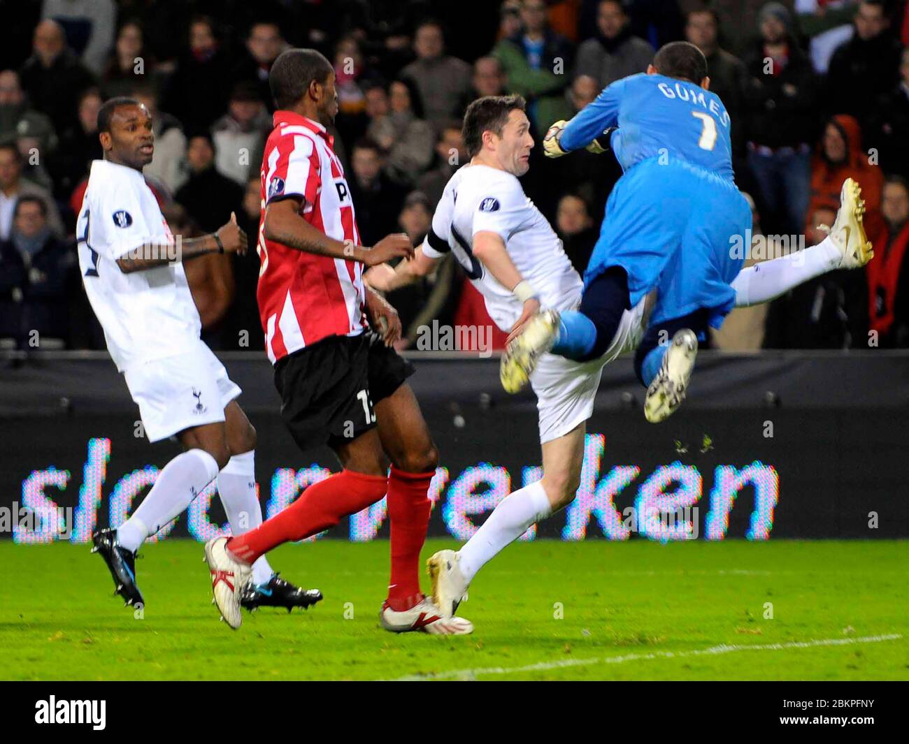 EINDHOVEN, NEDERLAND. MARCH 12: Robbie Keane (Spurs) gets flattened by Heurelho Gomes of PSV Eindhoven During UEFA Cup Round of 16 Second Leg between Stock Photo