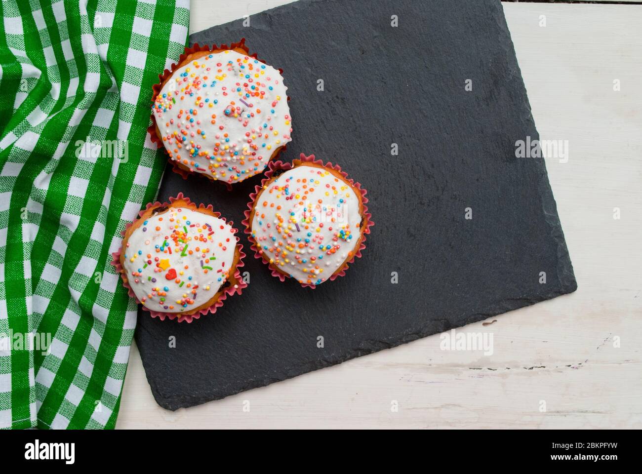 Three homemade muffins on a gray board Stock Photo