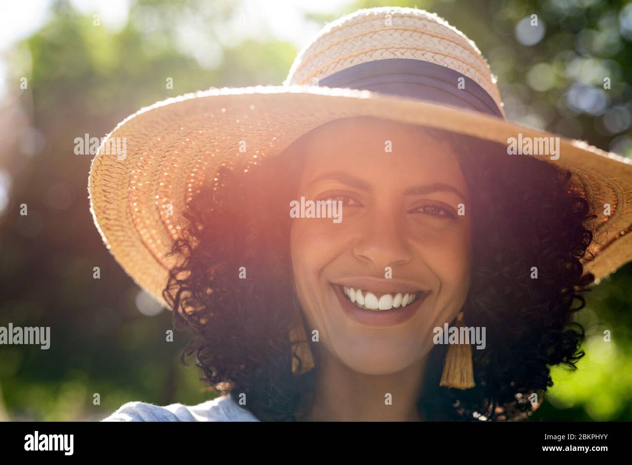 Smiling young woman wearing a hat on a sunny day Stock Photo