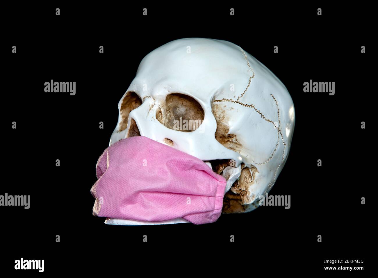 A human skull In Medical Mask on a dark background. Concept Of Deadly Coronavirus Epidemic. Stock Photo