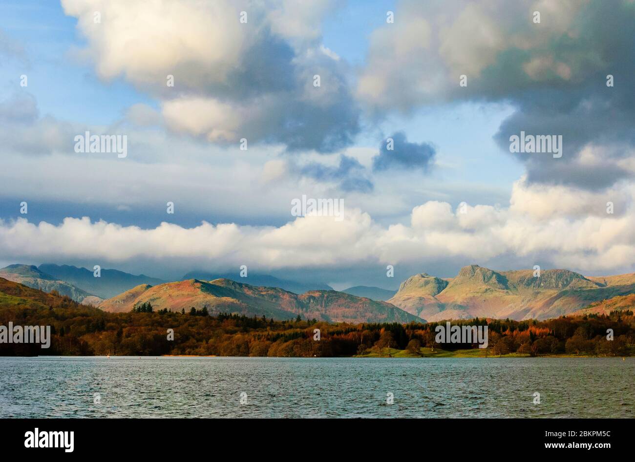 Looking across Windermere to Lingmoor Fell and the Langdale Pikes, with Crinkle Crags and Bowfell  in cloud. Stock Photo