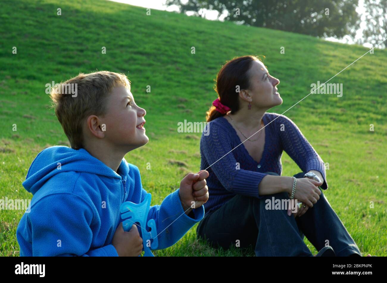 6 year old adopted boy flying a kite with his adopted mother UK Stock Photo