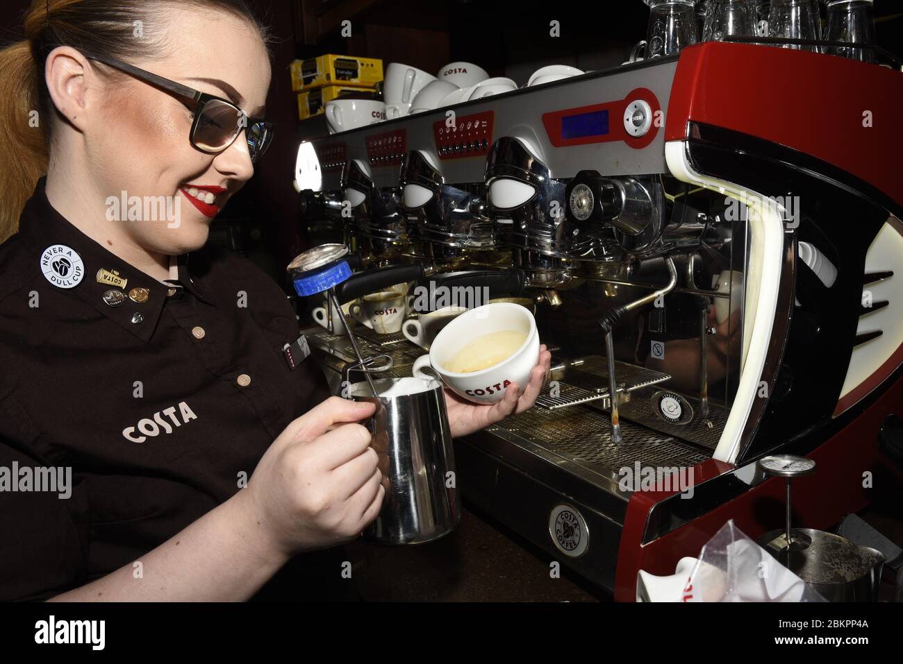 Costa coffee shop worker in store a barista making coffee Stock Photo
