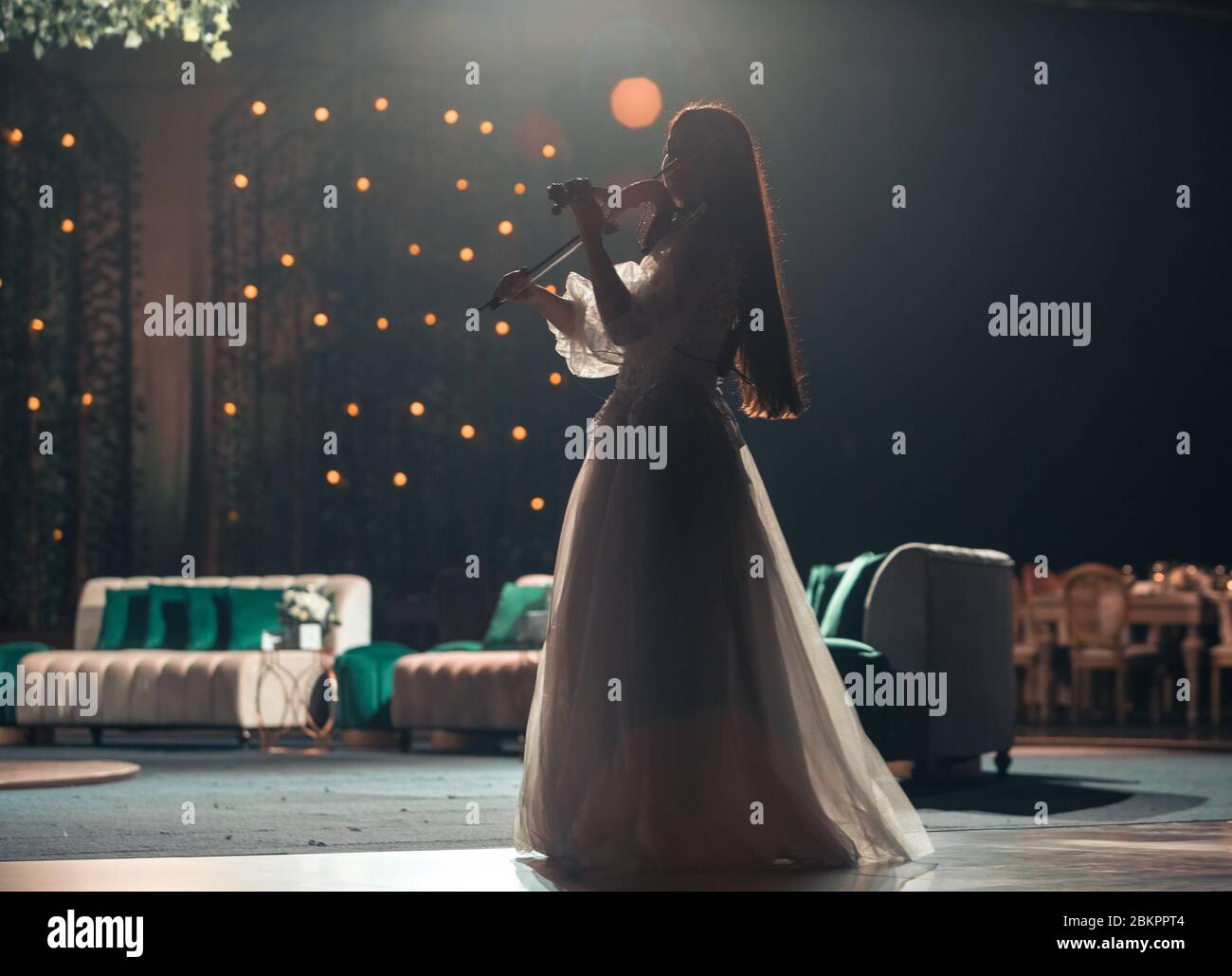 Girl in white dress plays violin on stage Stock Photo - Alamy