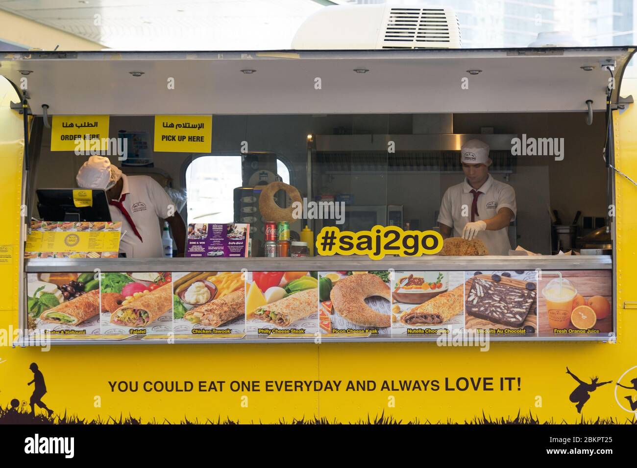 Street food outlet. Yellow cart on wheels with fast food Stock Photo