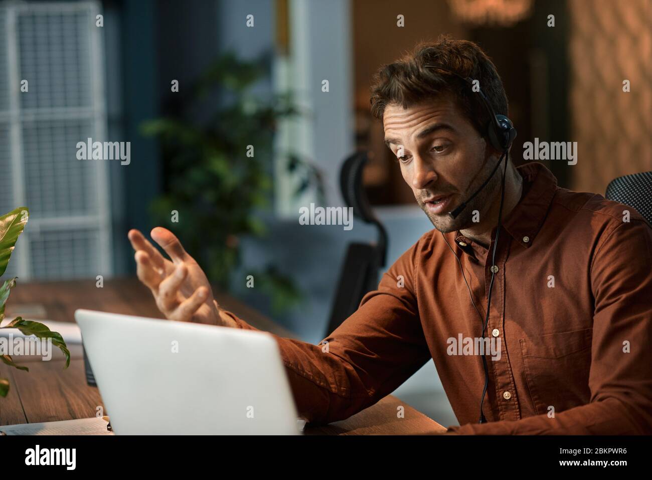 Businessman explaining something to a client over a headset Stock Photo