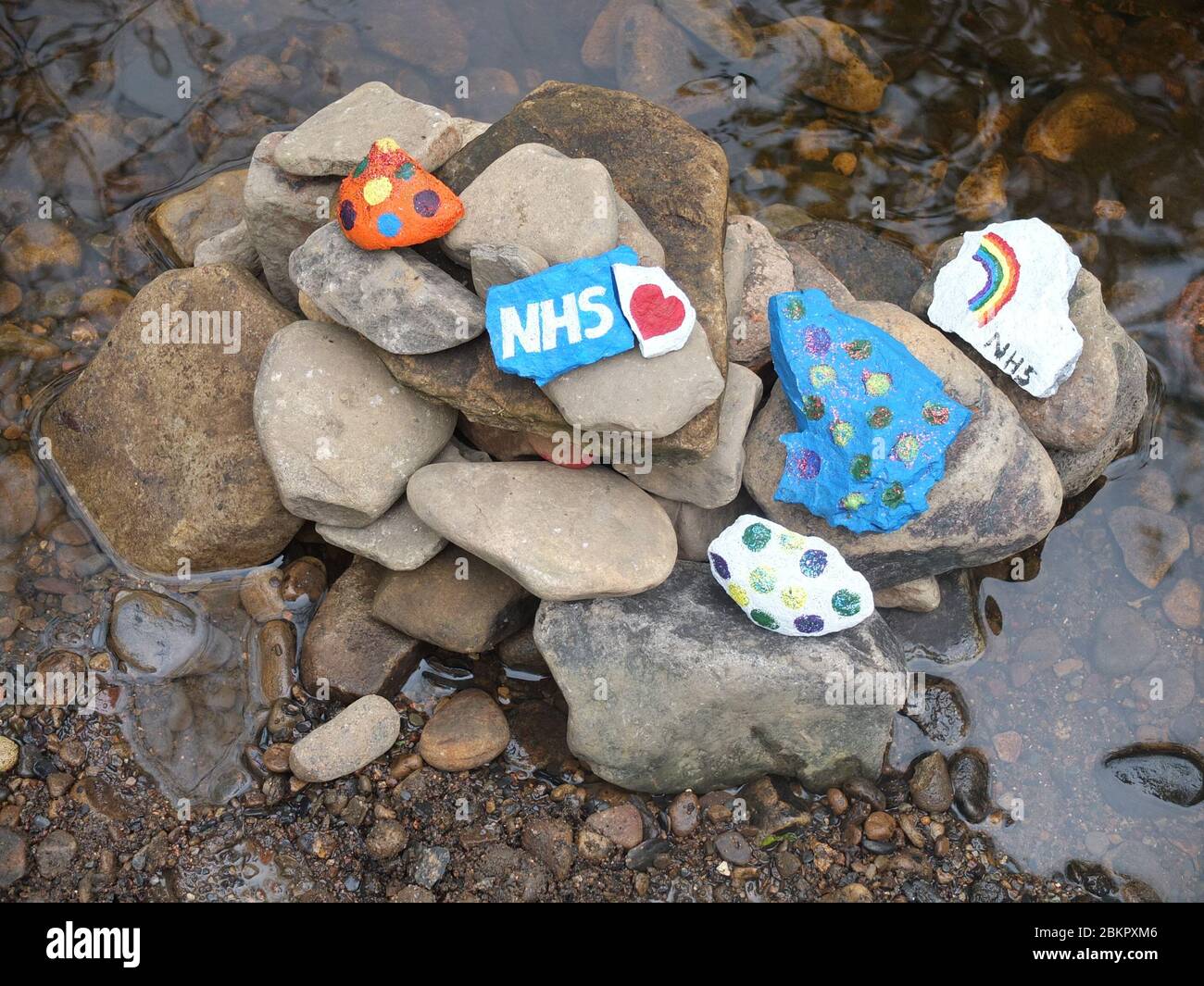 Painted stones with messages of gratitude for NHS at secret 'fairy garden' by river in Sheffield, UK, which has sprung up during Coronavirus Lockdown Stock Photo