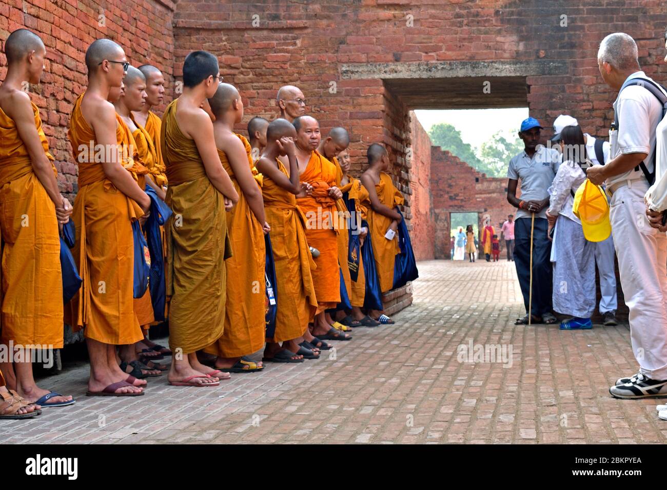Monks line up to visit the ruins of Nalanda Ancient University in Bihar. Stock Photo