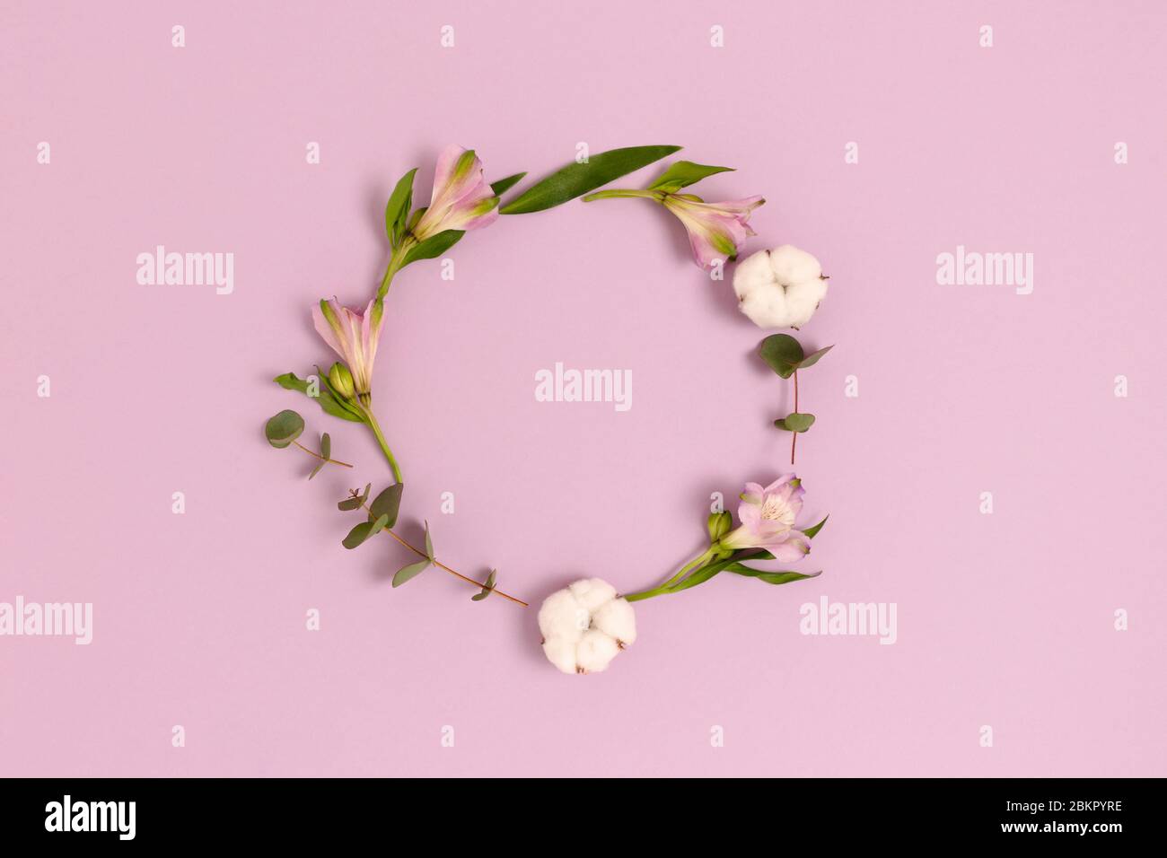 Round frame made of alstroemeria flowers, cotton and green leaves on a ...