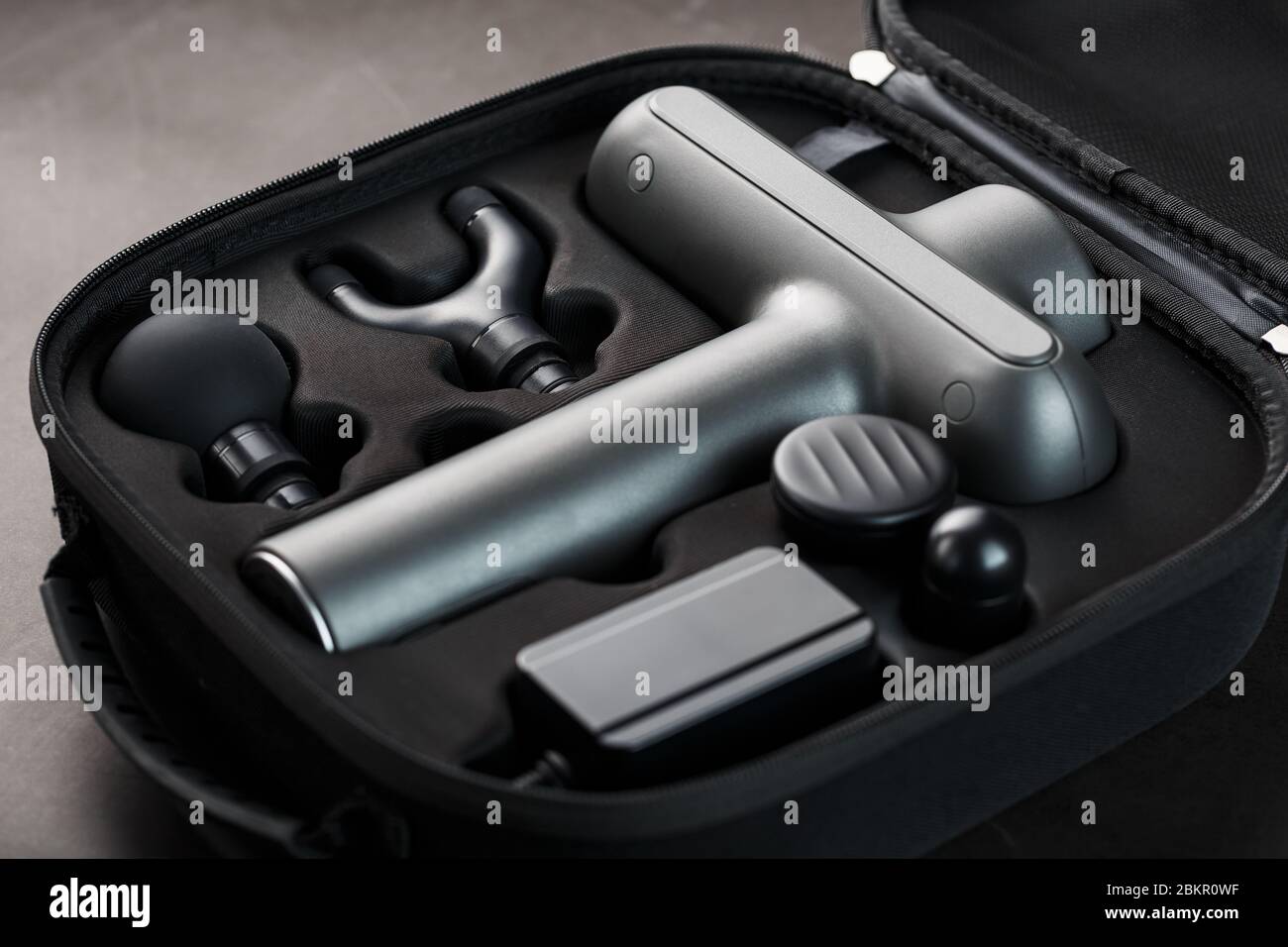 Electric massager Machine for body massage in a case on a black background.  Universal home massager for the whole body works on vibration technology  Stock Photo - Alamy