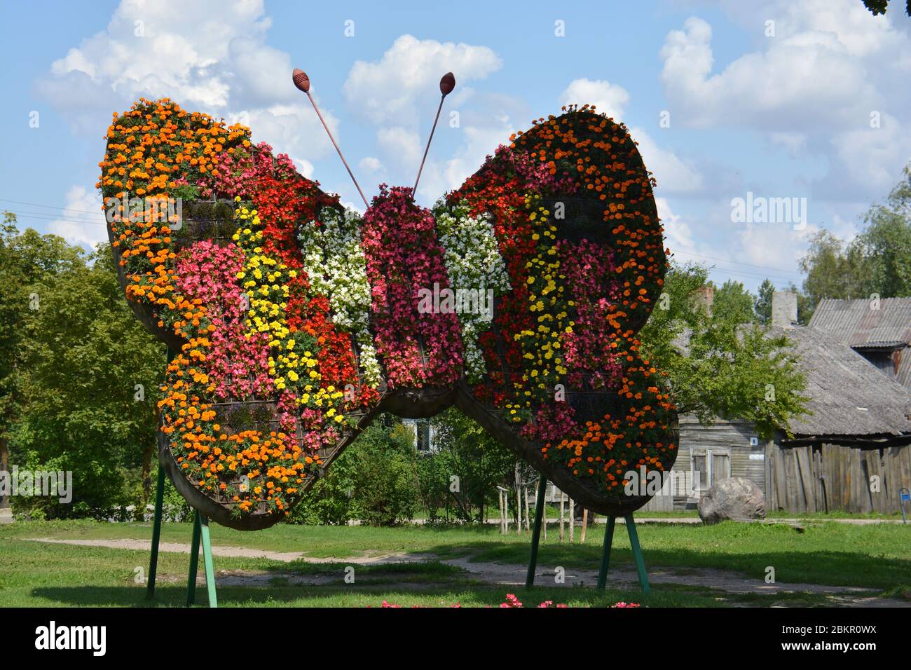 big butterfly symbol decoration made of many flowers in street Stock Photo