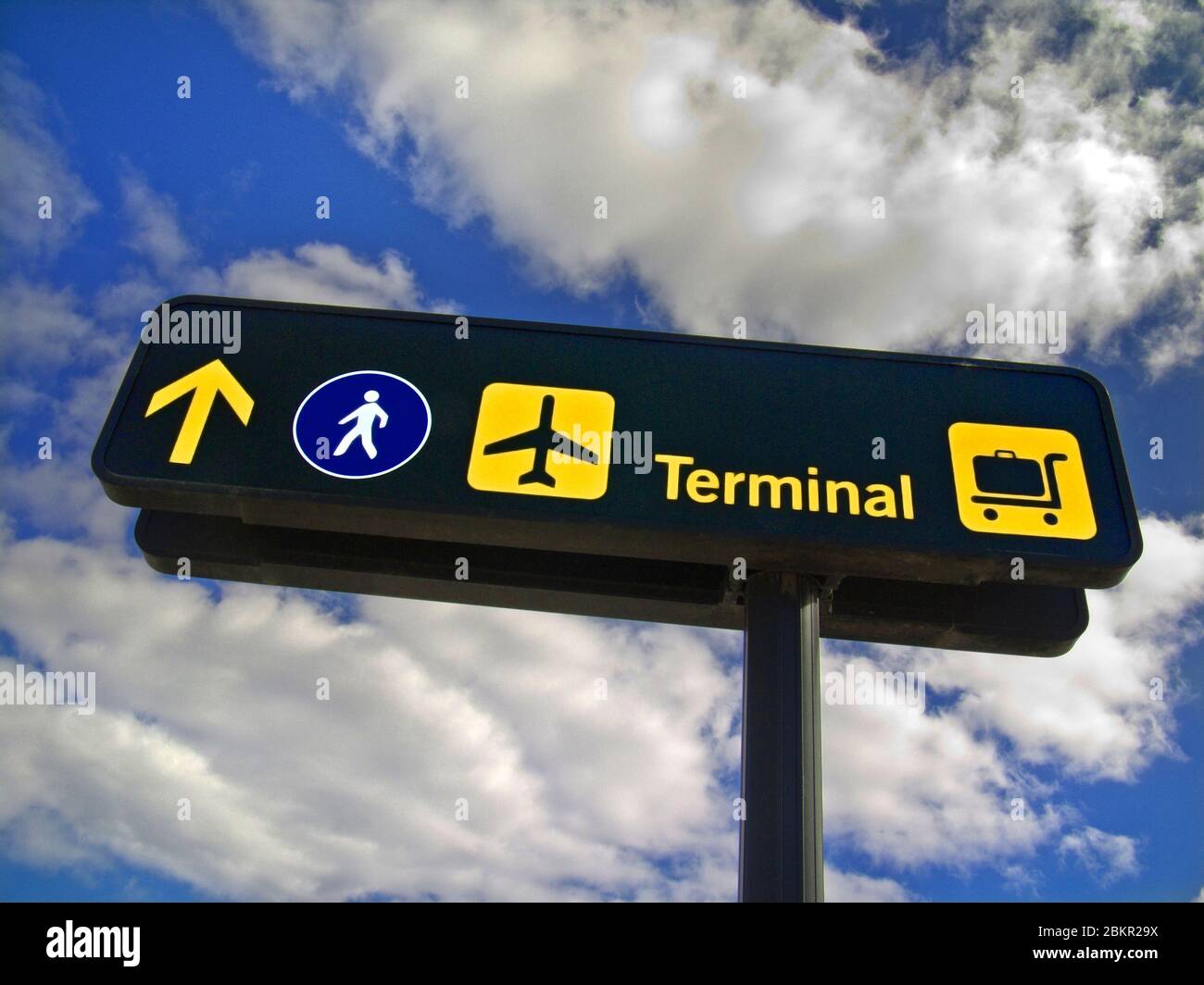 Airport terminal international travel information symbols signage for departing airline passengers, directing to terminals, airlines, baggage drop, walkway Stock Photo