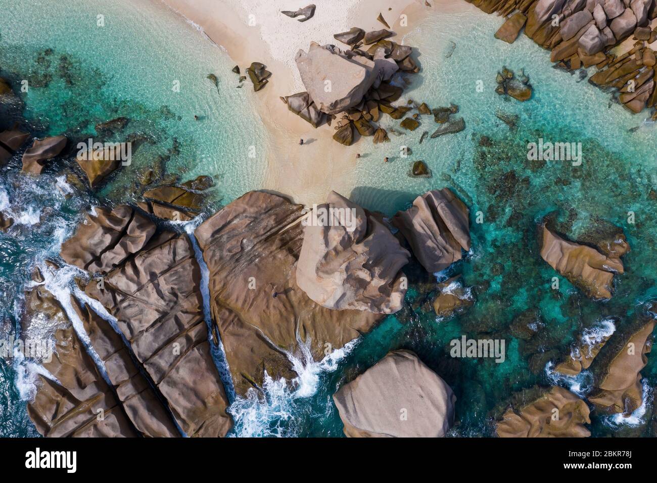 Seychelles, Digue island, Anse Marron, man and woman walking on the beach and granit rocks around (aerial view) Stock Photo