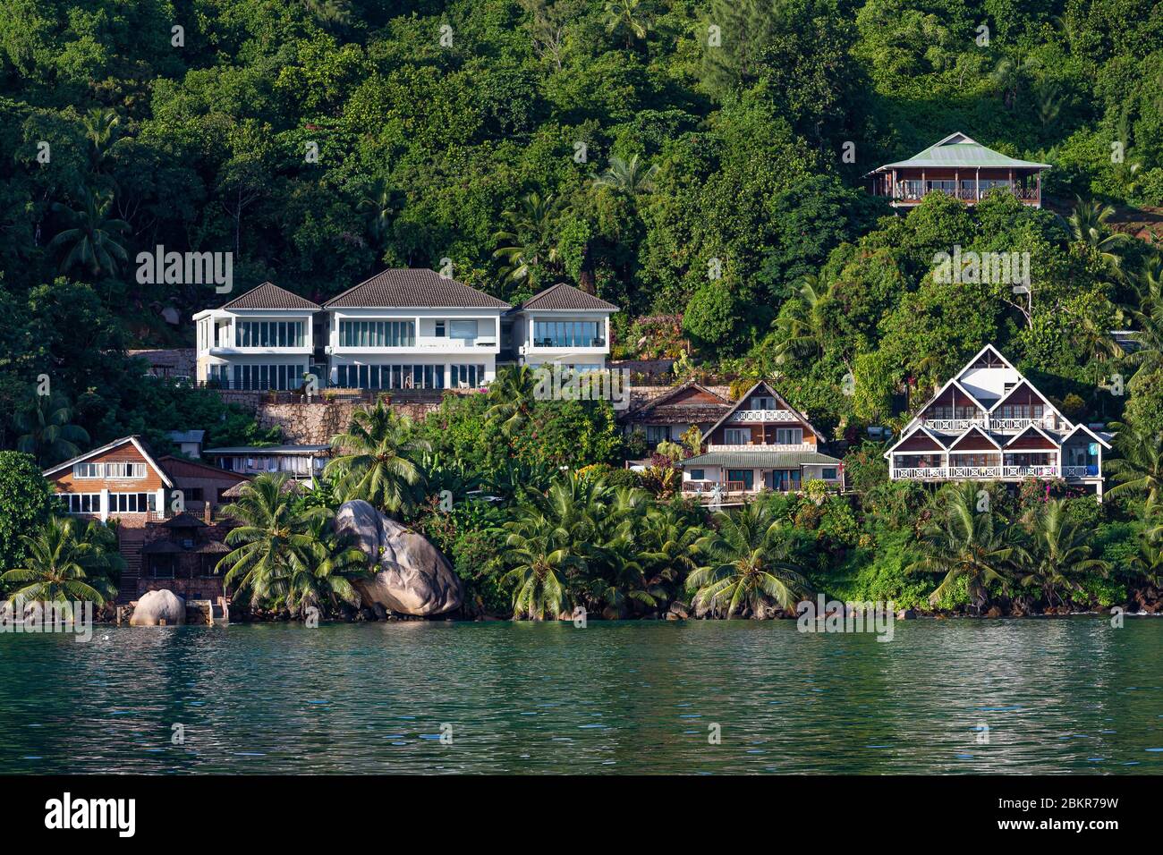 Seychelles, Praslin island, houses close to the sea with palms trees, takamaka trees and granit rocks Stock Photo