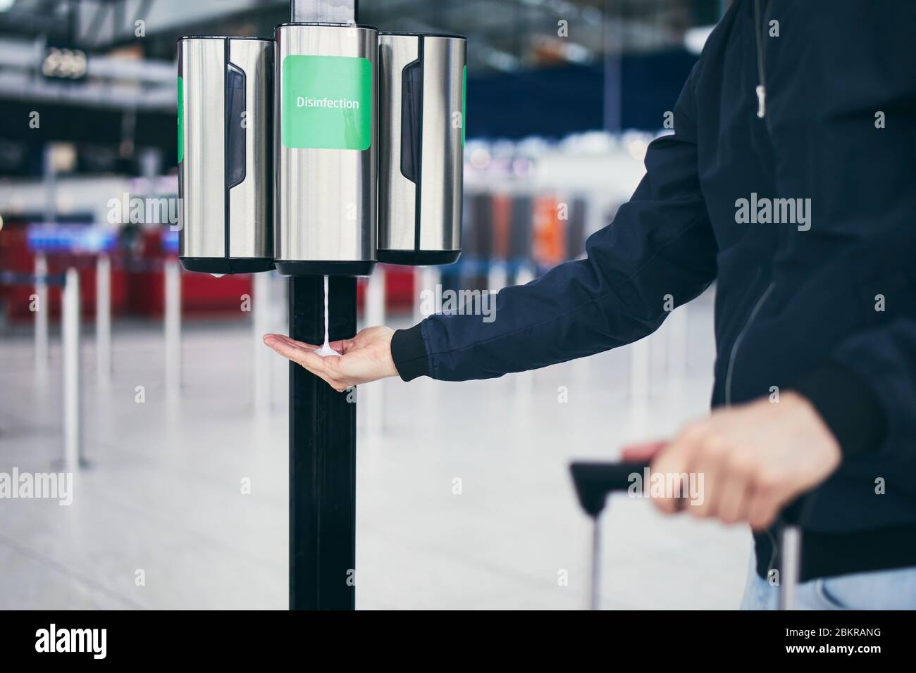 Man using hand sanitizer at airport. Themes traveling during pandemic