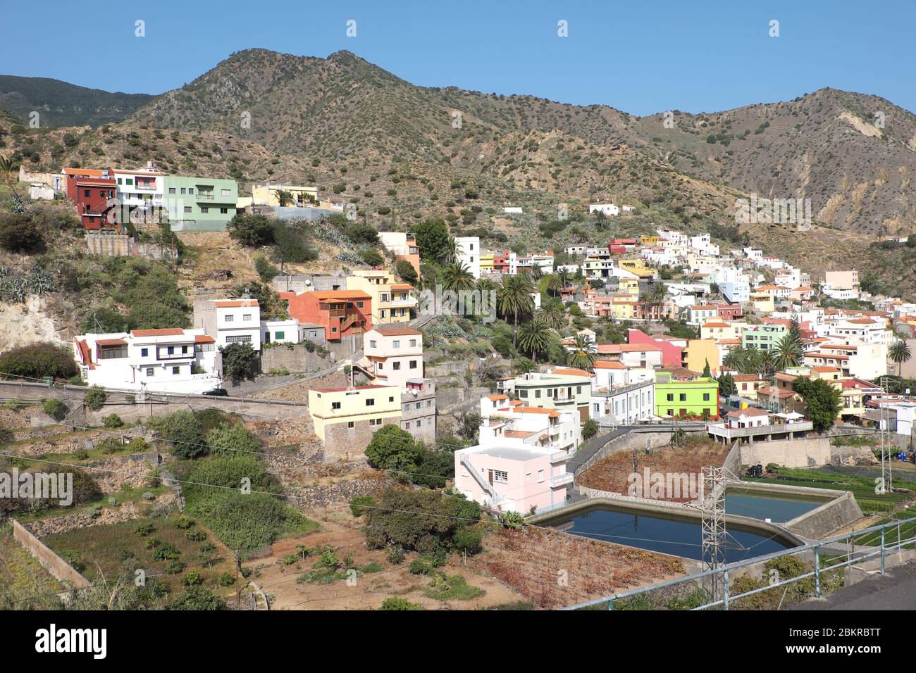 Colourful buildings hug the hillside in the small town of Vallehermoso on La Gomera, Canary Islands Stock Photo