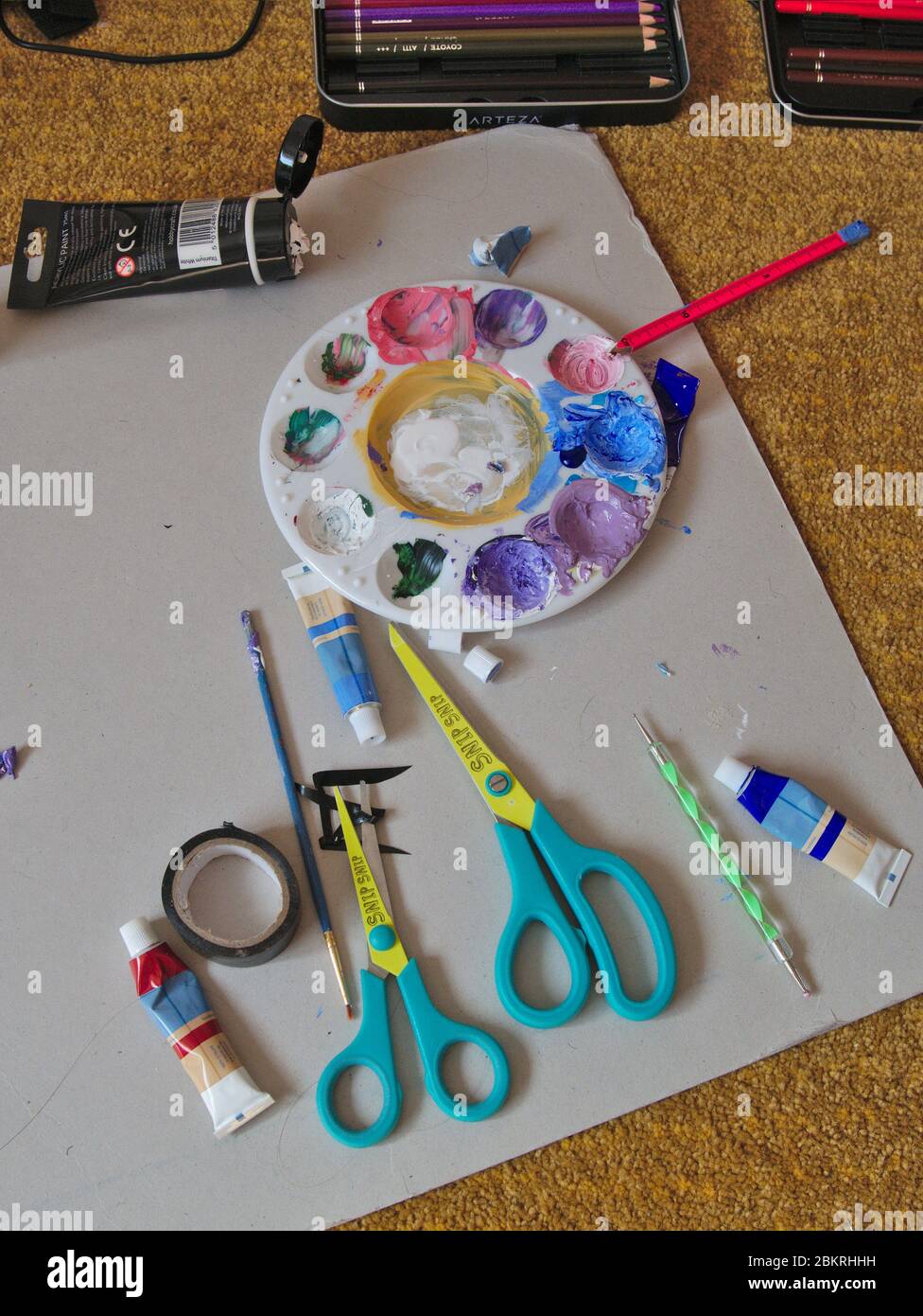 Child's art workspace with paints and brushes. Stock Photo