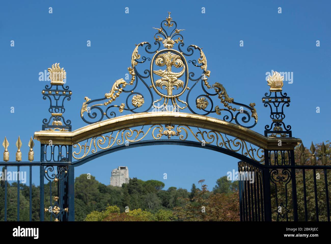 France, Gard, Nimes, Fontaine gardens, wrought iron gate gilded with gold and Magne tower Stock Photo