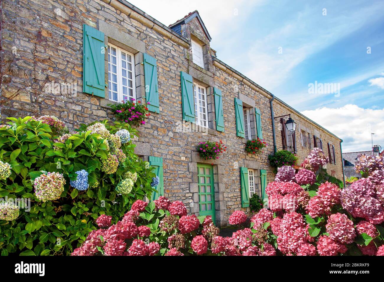 France, Morbihan, La Vraie Croix, Facade with green shutters of a flowered house with hydrangeas Stock Photo
