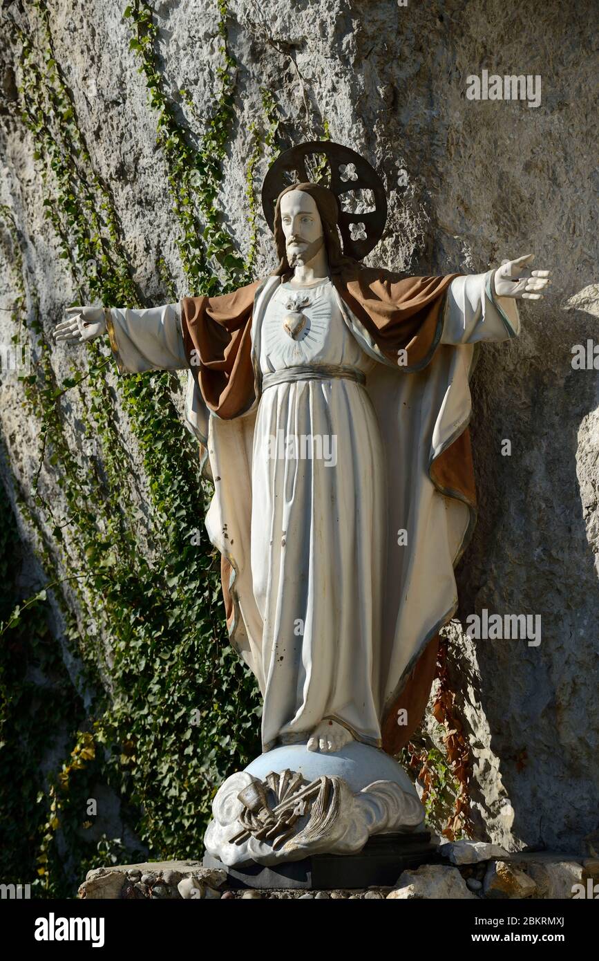 France, Haut Rhin, Ferrette, the Lourdes Grotto in 1905 in the cliff behind the church, the large cast iron statue of Christ Sacred Heart restored in 2017 Stock Photo