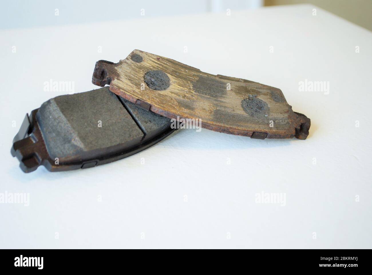 Worn out ruined disc brake pad compared to one that is new Stock Photo
