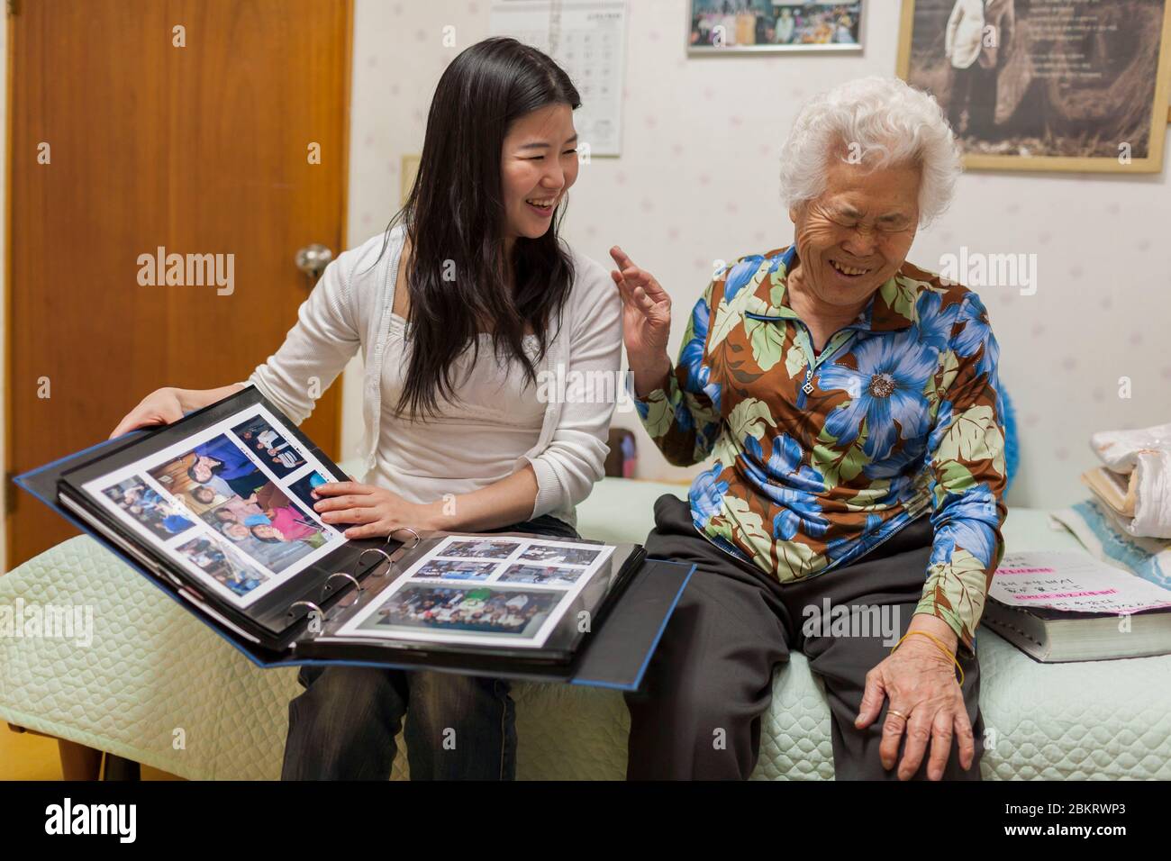 South Korea, Gyeonggi Province, Gwangju, near Seoul, House of Sharing, young Korean woman visits Yi Okseon in her room, meeting with surviving Comfort Women, sex slaves victims of Japanese soldiers, during pic