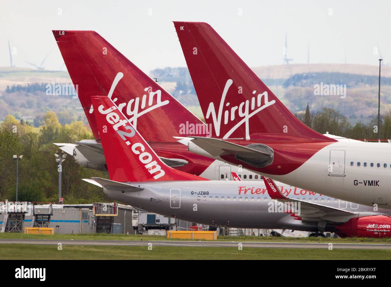 Glasgow, UK. 27th Apr, 2020. Pictured: Grounded Virgin Atlantic wide body jets at Glasgow Airport during the Coronavirus (COVID19) extended lockdown. Foreground is an Airbus A330-300 with the one behind a Boeing 747-400. Virgin Atlantic will also keep their operations closed at Gatwick which will have massive knock on effects for other airlines and the south of England. Credit: Colin Fisher/Alamy Live News. Stock Photo