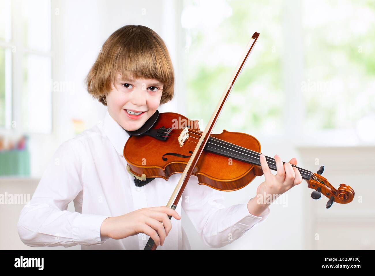 Child playing violin. Remote learning from home. Arts for kids. Little