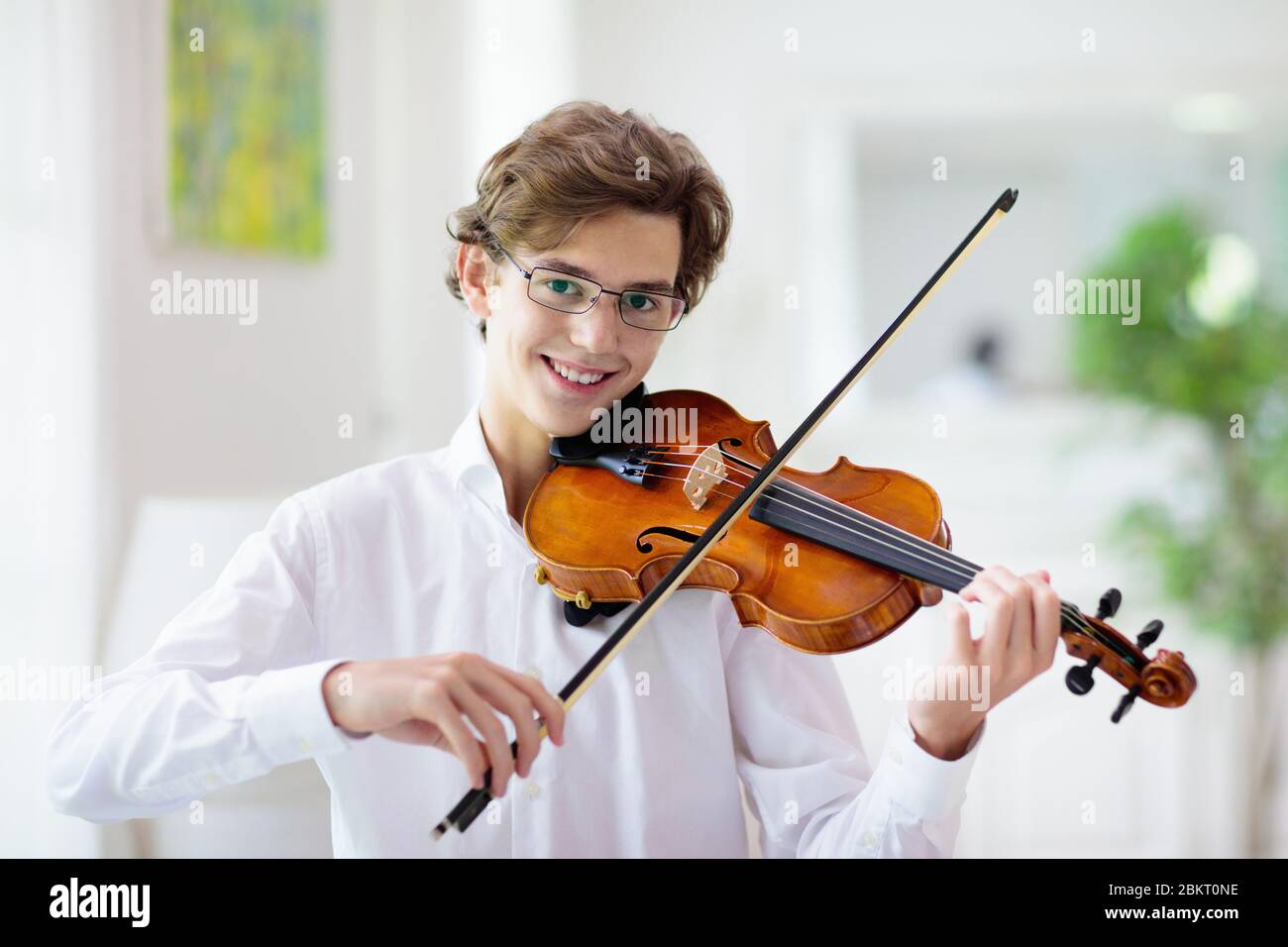 Man playing violin. Classical music instrument. Teenage boy practicing viola. Teenager art school student. Stock Photo