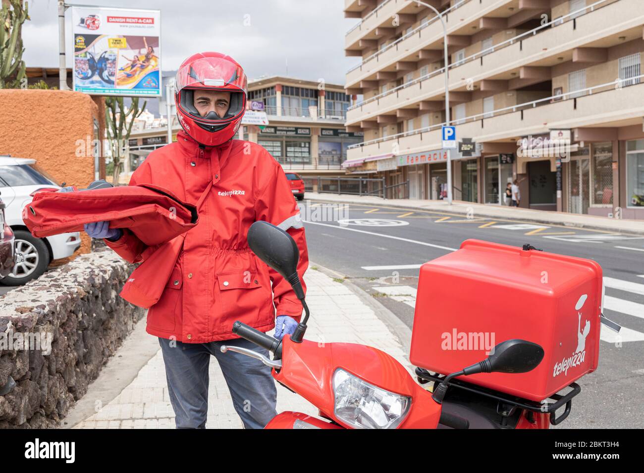 Telepizza pizza delivery guy with his scooter in callao Salvaje during the covid 19 lockdown in the tourist resort area of Costa Adeje, Tenerife, Cana Stock Photo