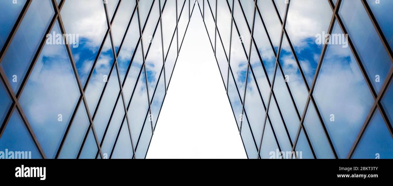 reflection of blue sky with white clouds in a window of a tall office ...