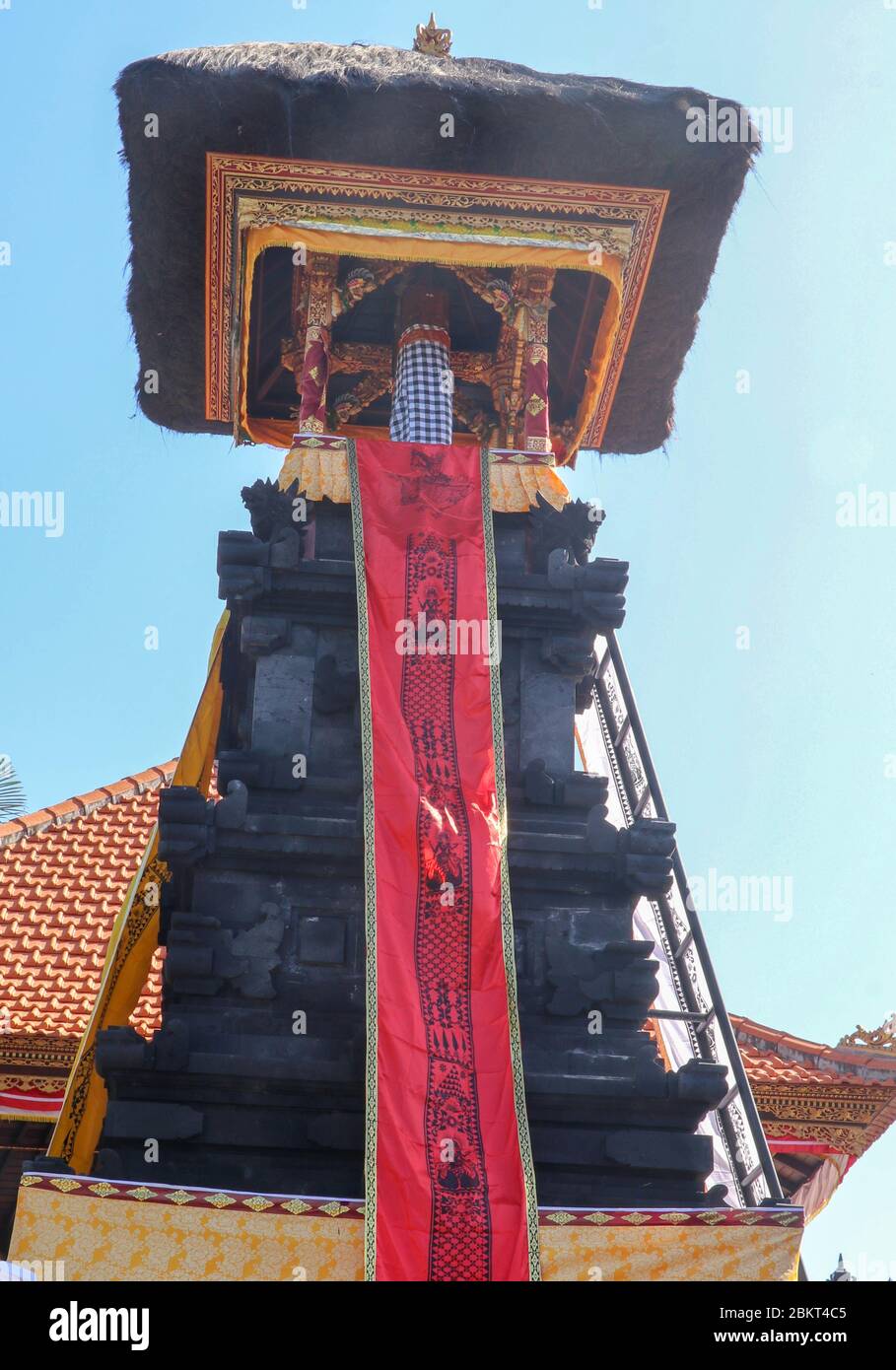 Traditional Balinese religion and architecture in Hindu temple Tanah Lot, Bali, Indonesia. Bale kulkul is a stone tower with a bell tower. Wooden bell Stock Photo