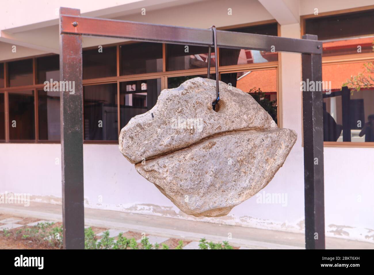 Decorative lucky rock boulder hanging on a chain in Buddhist temple, Thailand. Stock Photo
