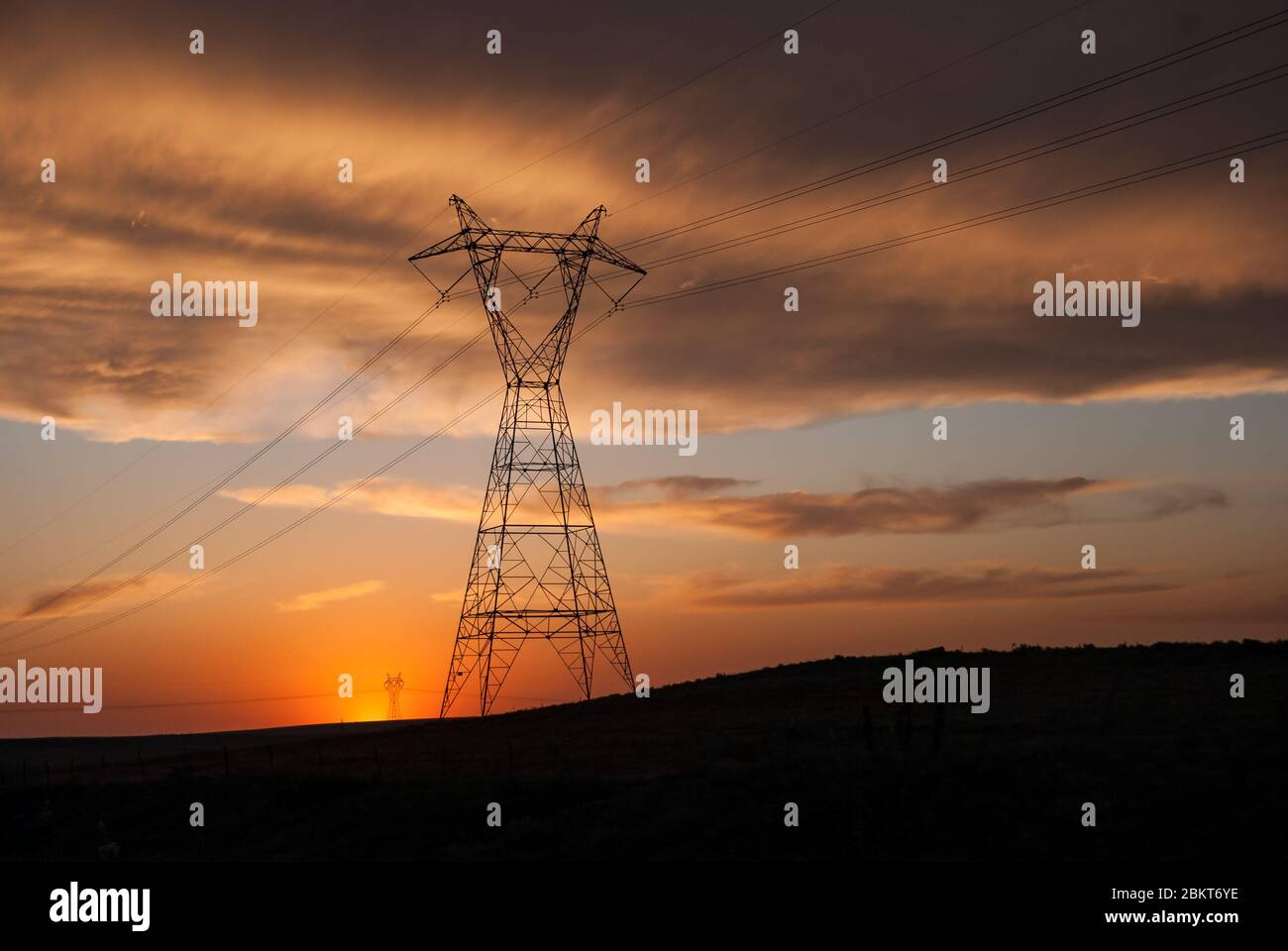 Power lines on a tower stretching across the open fields of the midwest