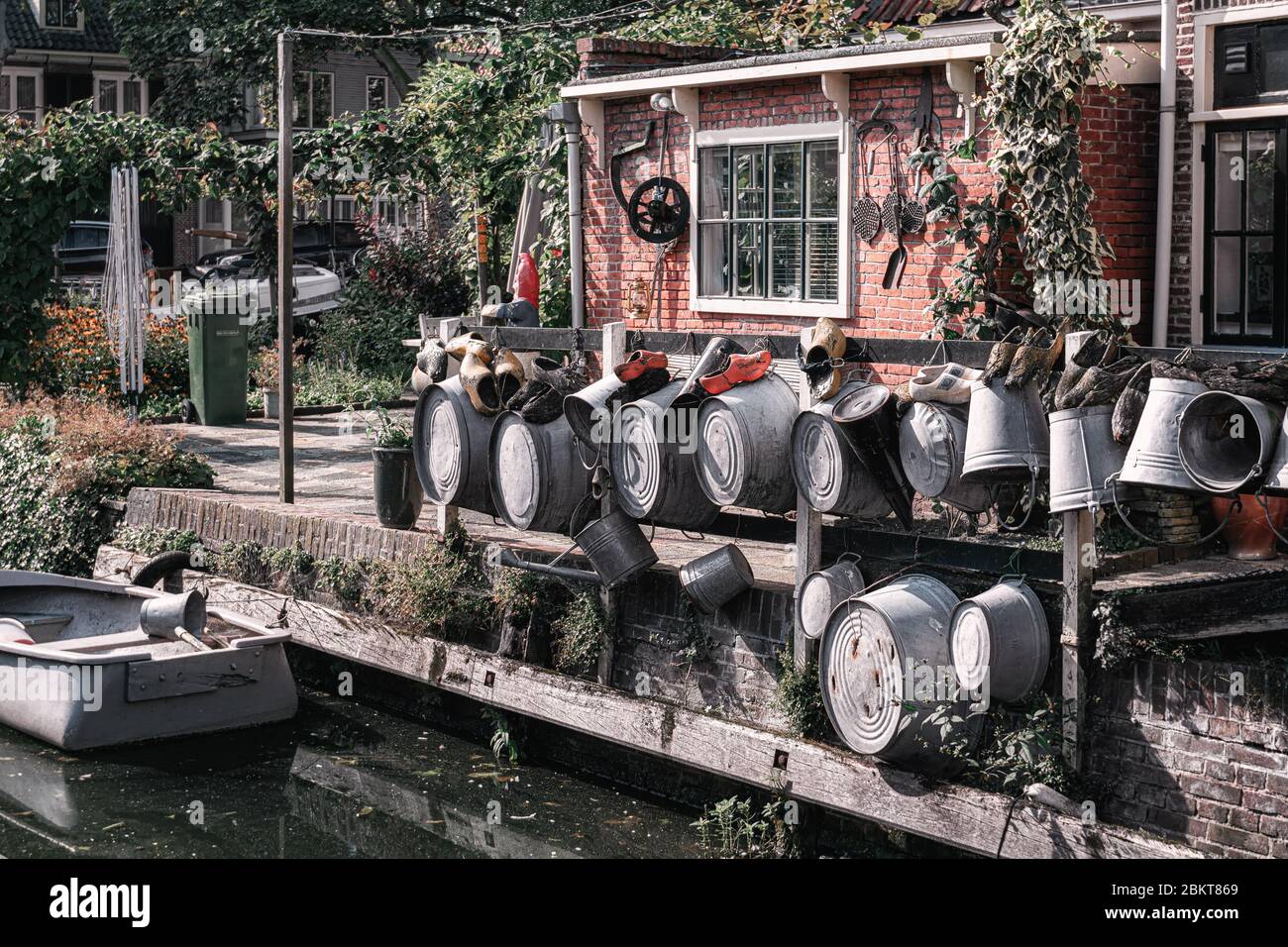 Edam, Netherlands, September 22, 2019:  The backyard at the canal in Edam decorated with zinc tubs, watering can and wooden clogs Stock Photo