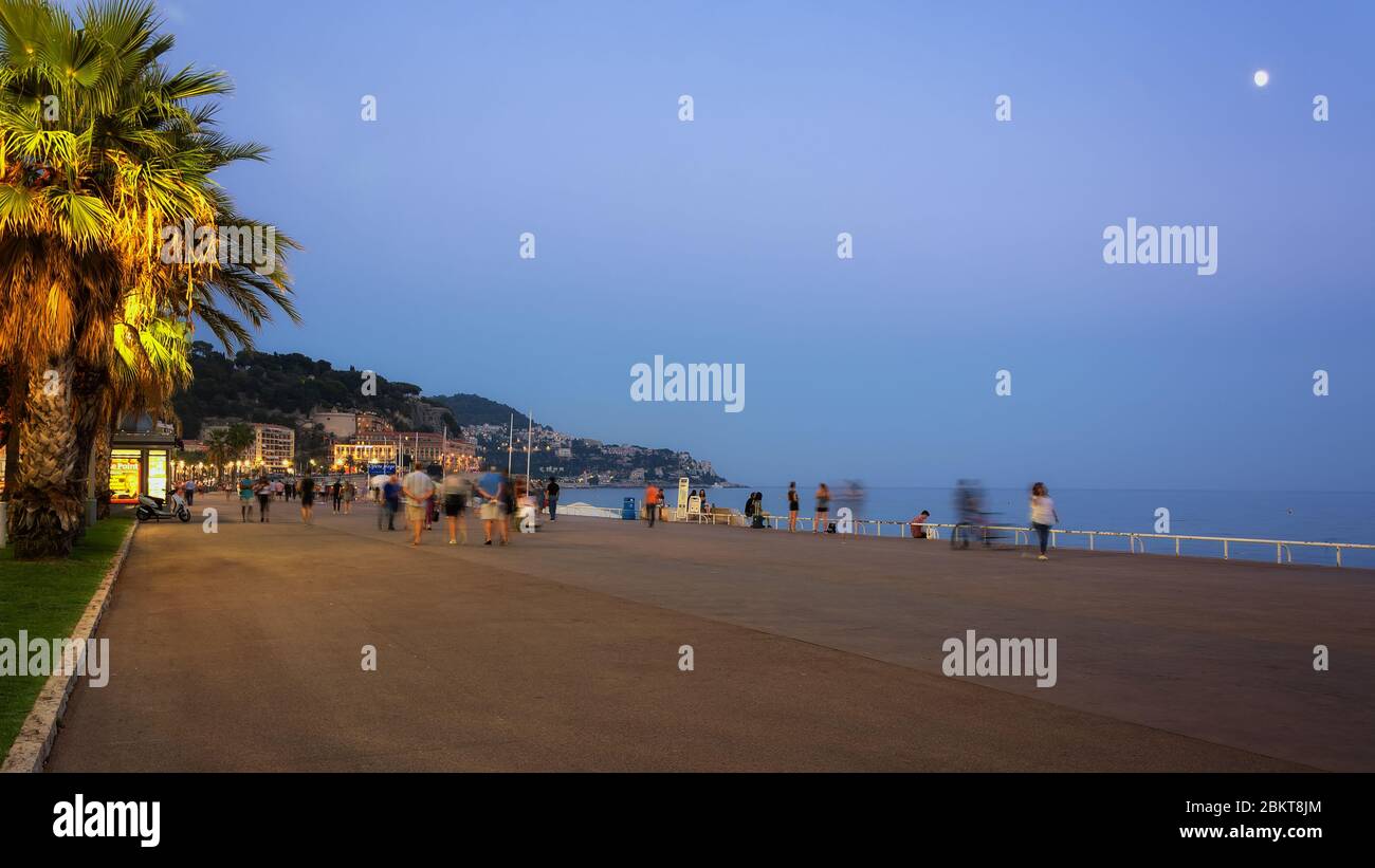 Nice, France, September 30, 2018: People enjoy a nice summer evening strolling along the beach promenade in Nice Stock Photo