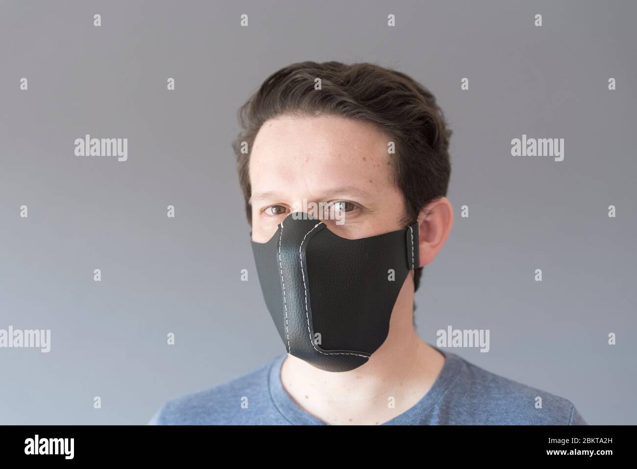 Portrait of a young man wearing a homemade reusable synthetic leather  protective face mask, to prevent the spread of the coronavirus disease, in  the c Stock Photo - Alamy