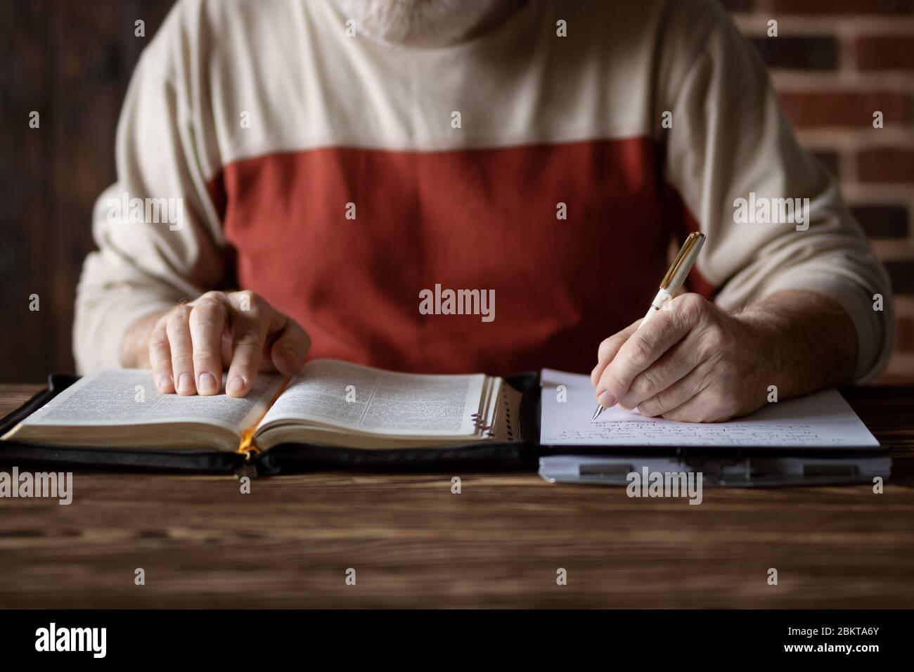 Bible study following the word of Scripture and copying it on paper. Taking notes and study of the Holy Bible. Searching for a spiritual subject Stock Photo