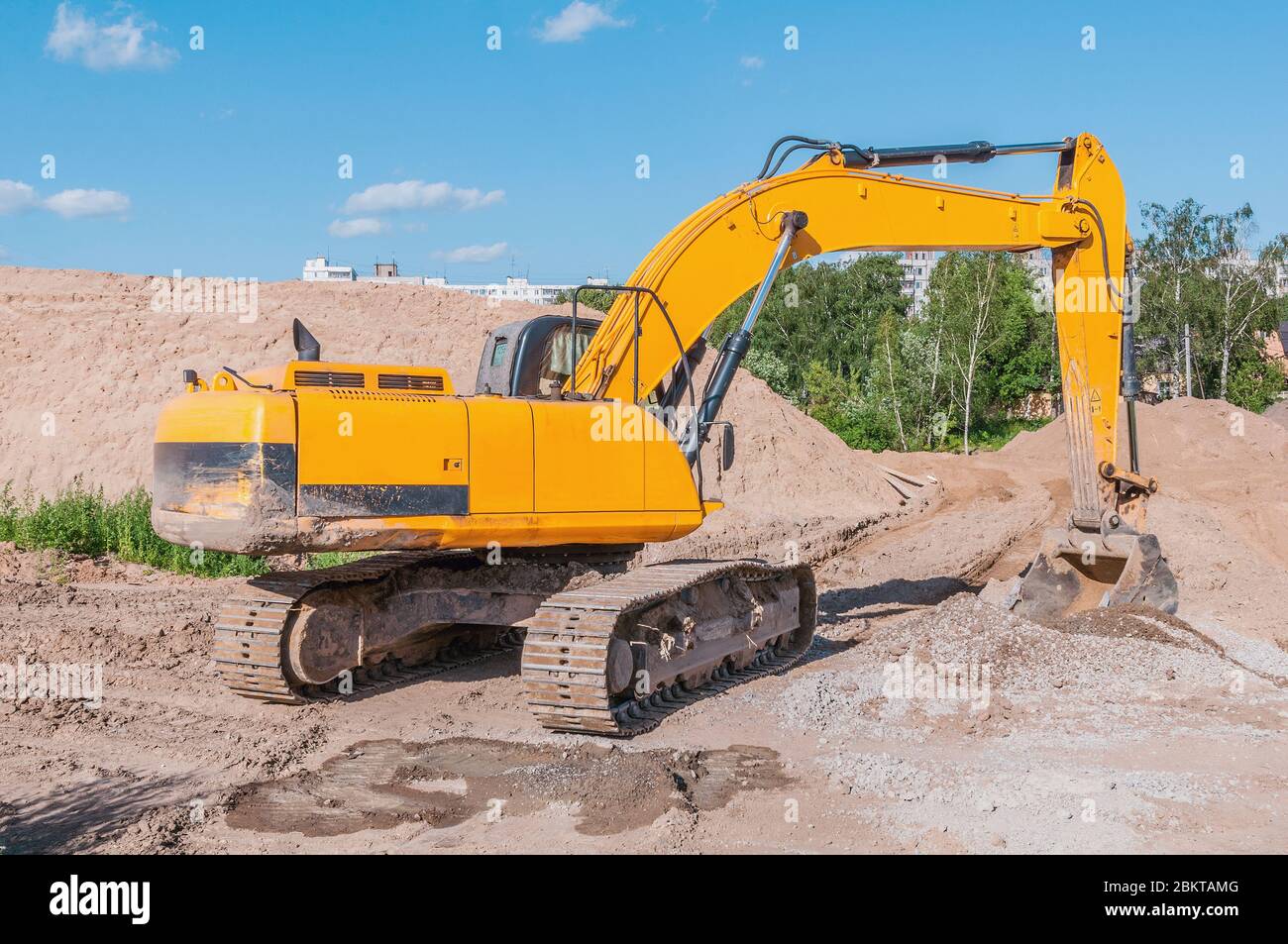 Excavator digs a hole on the construction site territory Stock Photo ...