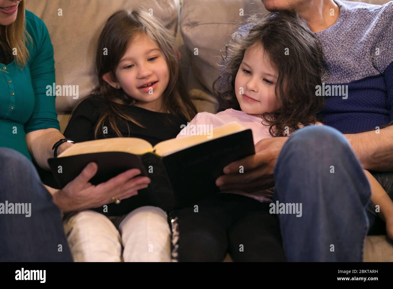 Grandparents teaching grandchildren about the Holy Bible Stock Photo