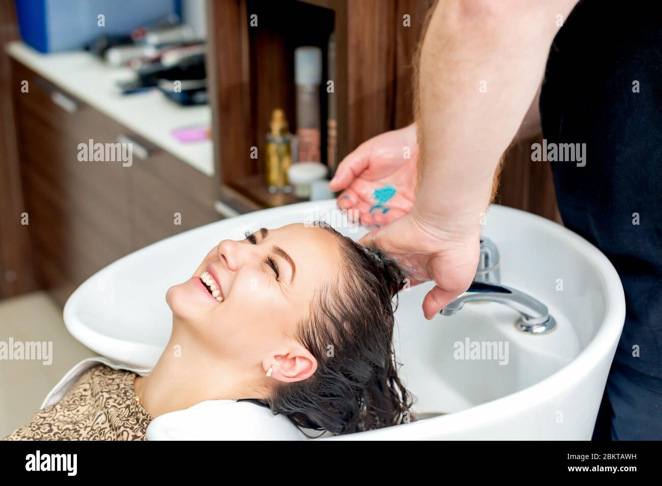 Woman receiving haircut. Hand of hairdresser washing hair of smiling woman in sink before getting a cut at hair salon Stock Photo - Alamy Woman receiving haircut. Hand of hairdresser washing hair of smiling woman in sink before getting a cut at hair salon Stock Photo - Alamy